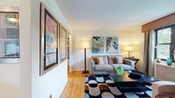 Located at 168A Richfield Ter in Clifton, NJ, this well-appointed single-floor residence offers a thoughtfully laid-out living space with warm hardwood flooring flowing throughout. The living room serves as the heart of the home, featuring large windows dressed with elegant floor-length drapes that allow natural light to fill the room. The space is complemented by a view of surrounding greenery, creating a welcoming and comfortable atmosphere. Colorful wall art and a bold geometric area rug add personality and visual interest to the room.

The kitchen is equipped with warm honey-toned wood cabinetry, white countertops, a stainless steel sink, and a gas range with overhead ventilation — providing a functional and efficient cooking space. The primary bedroom features a window overlooking lush outdoor greenery, hardwood floors, and ample room for furnishings. A secondary room with hardwood floors offers flexibility as a guest room or den. The full bathroom is finished with clean white tilework, a combined tub and shower with a glass sliding door, a white vanity with under-cabinet storage, and a small window for natural ventilation. Overall, this residence offers a practical and comfortable single-level layout in a convenient Clifton location.