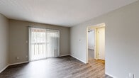 Located at 2903 W 42nd Ave in Kansas City, KS, this single-floor residence offers a clean and functional layout throughout. The living area is bright and open, featuring durable hardwood-style flooring in a cool gray tone, neutral-painted walls, and a large sliding glass door dressed with vertical blinds that allows generous natural light to fill the space. A closet with bifold doors provides convenient storage near the entryway.

The kitchen is well-appointed with white cabinetry offering ample upper and lower storage, dark countertops, tile backsplash, and a stainless steel electric range with an overhead ventilation hood. The layout provides a practical and efficient cooking environment.

The bedroom is carpeted for comfort and features a ceiling fan with a light fixture, a window with blinds for natural light and privacy, and a textured ceiling consistent throughout the unit. The room offers a quiet, comfortable retreat.

Additional spaces visible in the scan indicate utility and transitional areas, reflecting a straightforward and efficient floor plan. The overall aesthetic is neutral and move-in ready, with consistent finishes that lend a cohesive feel across the home. The single-level layout ensures ease of accessibility and smooth flow between living spaces.