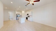 Located at 17224 Auburn Arch Loop in Wimauma, Florida, this two-story home offers a well-designed layout spread across two floors. The main level provides generous living space with light-toned tile flooring throughout, creating a clean and cohesive look. The open-concept kitchen is outfitted with white shaker cabinetry, a subway tile backsplash, quartz countertops, and stainless steel appliances including a side-by-side refrigerator, range, and microwave. The adjacent living room is bright and airy, with a staircase leading to the upper level. A screened patio off the main floor offers outdoor views of the surrounding neighborhood. Upstairs, three carpeted bedrooms provide comfortable retreats, including a spacious primary suite featuring a tray ceiling with a ceiling fan. The bathrooms are finished in a crisp, contemporary style with light wood-look tile floors, white vanities, and white subway tile surrounds — one bathroom includes a walk-in glass shower, while another features a tub-shower combo. A dedicated laundry room on the upper floor houses a full-size washer and dryer. The home also includes an attached garage with an automatic opener, adding everyday convenience to this well-appointed Florida residence.
