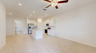 Located at 17224 Auburn Arch Loop in Wimauma, Florida, this two-story home offers a well-designed layout spread across two floors. The main level provides generous living space with light-toned tile flooring throughout, creating a clean and cohesive look. The open-concept kitchen is outfitted with white shaker cabinetry, a subway tile backsplash, quartz countertops, and stainless steel appliances including a side-by-side refrigerator, range, and microwave. The adjacent living room is bright and airy, with a staircase leading to the upper level. A screened patio off the main floor offers outdoor views of the surrounding neighborhood. Upstairs, three carpeted bedrooms provide comfortable retreats, including a spacious primary suite featuring a tray ceiling with a ceiling fan. The bathrooms are finished in a crisp, contemporary style with light wood-look tile floors, white vanities, and white subway tile surrounds — one bathroom includes a walk-in glass shower, while another features a tub-shower combo. A dedicated laundry room on the upper floor houses a full-size washer and dryer. The home also includes an attached garage with an automatic opener, adding everyday convenience to this well-appointed Florida residence.