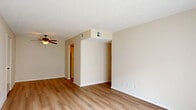This 2-bedroom, 1-bathroom apartment at 3704 Wyndham Way in Jeffersontown, KY offers a well-organized single-floor layout designed for comfortable everyday living. The spacious living room features warm wood-look laminate flooring, a ceiling fan with light fixture, and a textured ceiling. A large sliding glass door fills the room with natural light and opens to a private patio overlooking greenery outside. Neutral, warm-toned walls carry throughout the unit, creating a cohesive and inviting atmosphere.

The kitchen is efficiently arranged in an L-shaped layout with white cabinetry trimmed in warm wood tones, white countertops, a stainless steel double sink, and white appliances including a dishwasher, refrigerator, and electric range with overhead microwave. Wood-look flooring continues here, and an open pass-through connects the kitchen to the living area.

Both bedrooms are carpeted and feature textured ceilings, ample wall space, and good natural light. The primary bedroom is generously sized, while the second bedroom includes a built-in closet with sliding doors. The full bathroom is clean and functional, featuring tile flooring and a full tub-shower combination. A dedicated utility room and hallway with additional closet space round out the practical layout of this well-maintained home.