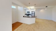 This single-floor residence offers a thoughtfully designed layout that balances open communal spaces with private retreats. The heart of the home is an open-concept kitchen and living area, where the kitchen features white cabinetry, dark granite countertops, stainless steel appliances including a refrigerator, range, and built-in microwave, and a breakfast bar with pendant lighting overhead. Hardwood-style flooring anchors the kitchen, which transitions seamlessly into the carpeted living area, brightened by a large window and a ceiling fan overhead.

The bedrooms are generously sized, each finished with plush wall-to-wall carpeting and equipped with ceiling fans for year-round comfort. Large windows allow natural light to flow in, offering pleasant outdoor views. A built-in vanity ledge with a granite surface and mirrored accents adds a refined touch to the primary suite area.

Two full bathrooms serve the residence, both finished with light tile flooring and white cabinetry topped with dark granite countertops. The primary bathroom includes a walk-in closet with built-in shelving, a soaking tub, and a separate shower. The secondary bathroom features a tub-shower combination. Throughout the space, a clean, neutral palette creates a bright and welcoming atmosphere.