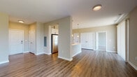 This thoughtfully designed single-floor residence at 2100 Haddonfield Rd in Pennsauken, NJ offers a clean, contemporary aesthetic throughout. The open-concept living and dining area is anchored by rich hardwood-style flooring and neutral warm-toned walls, creating a bright and welcoming atmosphere. A large sliding glass door floods the living space with natural light while offering pleasant outdoor views, complemented by vertical blinds for privacy.

The modern kitchen is a standout feature, centered around a generous peninsula with a white countertop and integrated sink, ideal for both meal preparation and casual dining. Light wood cabinetry pairs elegantly with a white tile backsplash, and the space is fully equipped with stainless steel appliances including a refrigerator, gas range, and microwave. Pendant lighting and a track light fixture add both function and style.

The bedrooms are carpeted for comfort and benefit from abundant natural light through large windows with outdoor views. Ample closet space is provided, including built-in shelving. The bathrooms are finished to a high standard — one features a soaking tub with white subway tile surround, while the other offers a walk-in shower with sliding glass doors. Both bathrooms include navy blue vanity cabinetry with white countertops and wood-look flooring.