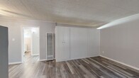 Located in Arden-Arcade, Sacramento, this single-story, one-bedroom, one-bathroom unit offers an efficiently designed layout across a single floor. The interior features consistent luxury vinyl plank flooring in a warm gray tone throughout, lending a cohesive, modern feel to every room.

The living area is brightened by a large window dressed with vertical blinds, allowing natural light to filter in while providing a view of the surrounding greenery. The space flows into a dedicated dining area and a functional kitchen fitted with white cabinetry and a clean, simple aesthetic.

The bedroom is a comfortable size, featuring a wall of built-in closet storage with double doors, providing generous organizational space. A tall wall-mounted heater unit is also present, ensuring climate control. The textured ceiling tile adds a classic character to the room.

Two closets are available throughout the unit, offering practical storage solutions. The bathroom includes a white vanity with cabinet storage below, a walk-in shower with marble-style tile surround, a natural light-admitting window, and wood-look flooring that complements the rest of the unit.

Throughout, the walls are finished in soft, neutral gray tones, creating a calm and clean atmosphere well-suited for comfortable everyday living.