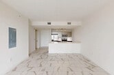 Located at 101 E Camino Real in the heart of Boca Raton, FL, this thoughtfully designed one-bedroom, one-bathroom residence offers a clean, modern aesthetic throughout. Elegant large-format marble-look porcelain tile flows seamlessly across every room, lending a bright and cohesive feel to the entire space.

The open-concept living area integrates the dining room, kitchen, and living room into one expansive, light-filled zone. The kitchen features a peninsula with white quartz countertops, rich walnut-toned cabinetry, stainless steel appliances including a refrigerator, range, and microwave, and recessed track lighting overhead. Sliding glass doors in the living area open onto a private balcony with decorative iron railings, offering open city views.

The spacious primary bedroom is filled with natural light from a large window with blinds and provides access to three generous closets with built-in wire shelving for ample storage. A dedicated laundry area adds everyday convenience.

The bathroom is elegantly appointed with floor-to-ceiling marble-look tile surrounding the soaking tub and shower, a walnut vanity with a white undermount sink, and a large mirror. A hallway connects the private and shared spaces. The unit also includes an in-unit laundry area, completing this well-appointed Boca Raton residence.