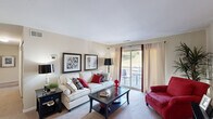 Located at 5 Maidstone Ct in Rosedale, MD, this single-floor, two-bedroom, one-bathroom home offers a well-organized and thoughtfully designed layout. The living room serves as the heart of the space, featuring plush carpeting, neutral walls, and a sliding glass door that opens to a private balcony with outdoor views — filling the room with natural light. The dining area adjoins the living space and provides a cozy setting accented by warm artwork and stylish furnishings. The galley-style kitchen is efficiently designed with warm wood cabinetry, granite-look countertops, black appliances, tile flooring, and the added convenience of an in-unit washer and dryer. The primary bedroom is a comfortable retreat with soft carpeting, a large closet, and natural light filtering through curtained windows. The second bedroom also features a roomy closet with built-in shelving. The full bathroom makes a bold statement with a rich red accent wall, granite vanity, wood cabinetry, and tile flooring. Two hallways connect the rooms seamlessly, and an additional closet provides practical storage. The space combines functional design with inviting, vibrant décor throughout.