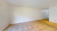 Located in Hollywood, FL, this single-floor, 2-bedroom, 1-bathroom home offers a practical and well-organized layout. The combined living and dining area is bright and open, featuring light ceramic tile flooring throughout and a large sliding glass door that floods the space with natural light and opens to a view of lush green lawn. A dedicated entrance leads into a hallway connecting the main living areas, with four closets providing generous storage throughout the unit. The kitchen is efficiently designed with white cabinetry, granite-style countertops, a stainless steel refrigerator, electric range, and dishwasher, complemented by a window that brings in additional natural light. Both bedrooms are carpeted and offer a comfortable, quiet retreat — the primary bedroom features a wide, louvered bi-fold closet spanning nearly the full wall. The second bedroom is accessed conveniently near the in-unit laundry area. The bathroom is clean and functional, featuring a full tub-shower combination with white tile surround and modern chrome fixtures. Throughout the home, textured ceilings, white walls, and consistent flooring choices create a cohesive, light-filled atmosphere well-suited to South Florida living.