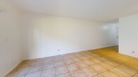 Located in Hollywood, FL, this single-floor, 2-bedroom, 1-bathroom home offers a practical and well-organized layout. The combined living and dining area is bright and open, featuring light ceramic tile flooring throughout and a large sliding glass door that floods the space with natural light and opens to a view of lush green lawn. A dedicated entrance leads into a hallway connecting the main living areas, with four closets providing generous storage throughout the unit. The kitchen is efficiently designed with white cabinetry, granite-style countertops, a stainless steel refrigerator, electric range, and dishwasher, complemented by a window that brings in additional natural light. Both bedrooms are carpeted and offer a comfortable, quiet retreat — the primary bedroom features a wide, louvered bi-fold closet spanning nearly the full wall. The second bedroom is accessed conveniently near the in-unit laundry area. The bathroom is clean and functional, featuring a full tub-shower combination with white tile surround and modern chrome fixtures. Throughout the home, textured ceilings, white walls, and consistent flooring choices create a cohesive, light-filled atmosphere well-suited to South Florida living.