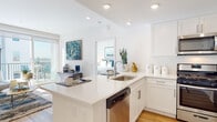 Located at 310 K St in Chula Vista, California, this modern single-floor residence offers a thoughtfully designed open-concept layout with contemporary finishes throughout. Light hardwood flooring runs seamlessly across the living spaces, complementing the clean, neutral palette of the interior.

The kitchen is a standout feature, outfitted with crisp white shaker cabinetry, quartz countertops, a central island with an undermount sink and dishwasher, and a full suite of stainless steel appliances including a gas range, microwave, and refrigerator. The kitchen opens directly into the living area, promoting an airy, connected feel.

The living room is bathed in natural light, courtesy of a large sliding glass door that leads to a private balcony with open views of the surrounding neighborhood. The balcony provides an ideal space for outdoor relaxation.

Two well-proportioned bedrooms each benefit from natural light through windows with views of the surrounding area, and are finished with the same warm hardwood flooring. Both bathrooms mirror the kitchen's design language, featuring white shaker vanity cabinets, quartz countertops, large mirrors, and clean, modern fixtures.

Overall, the residence presents a bright, contemporary atmosphere with consistent high-quality finishes throughout.