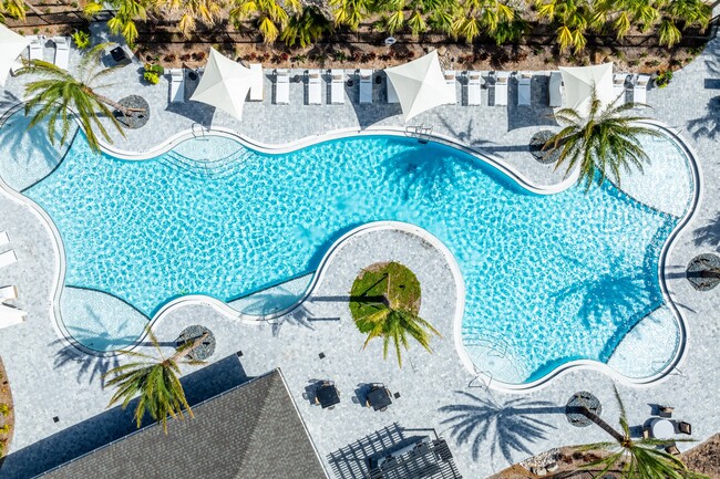 Piscina de agua salada estilo resort con plataforma para tomar el sol - Olana Waterside