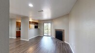This single-story, 1-bedroom, 1-bathroom residence offers a thoughtfully designed layout that maximizes functionality and comfort. The open-concept living, dining, and kitchen area serves as the heart of the home, featuring dark hardwood-style flooring that flows throughout the main living spaces. A standout brick fireplace anchors the living room, while a sliding glass door opens to a private balcony with outdoor views of surrounding greenery, filling the space with natural light.

The kitchen is well-equipped with warm wood cabinetry, light speckled countertops, a double sink, and black appliances including a gas range, microwave, and refrigerator. A pass-through counter connects the kitchen to the dining and living areas, enhancing the open feel.

The bedroom is carpeted for comfort and features a large window with blinds that allows ample natural light. It includes a dedicated closet with built-in shelving and hanging rods, providing generous storage. The full bathroom is finished with wood cabinetry, a speckled countertop vanity, a large mirror, and a shower-tub combination.

Additional features include an entrance area, a dedicated laundry space, and consistent neutral-toned walls throughout that create a clean, cohesive aesthetic across the entire residence.