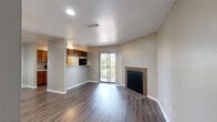 This single-story, 1-bedroom, 1-bathroom residence offers a thoughtfully designed layout that maximizes functionality and comfort. The open-concept living, dining, and kitchen area serves as the heart of the home, featuring dark hardwood-style flooring that flows throughout the main living spaces. A standout brick fireplace anchors the living room, while a sliding glass door opens to a private balcony with outdoor views of surrounding greenery, filling the space with natural light.

The kitchen is well-equipped with warm wood cabinetry, light speckled countertops, a double sink, and black appliances including a gas range, microwave, and refrigerator. A pass-through counter connects the kitchen to the dining and living areas, enhancing the open feel.

The bedroom is carpeted for comfort and features a large window with blinds that allows ample natural light. It includes a dedicated closet with built-in shelving and hanging rods, providing generous storage. The full bathroom is finished with wood cabinetry, a speckled countertop vanity, a large mirror, and a shower-tub combination.

Additional features include an entrance area, a dedicated laundry space, and consistent neutral-toned walls throughout that create a clean, cohesive aesthetic across the entire residence.