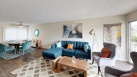 Located at 2636 Grand Avenue in San Diego's vibrant Pacific Beach neighborhood, Unit 220 is a thoughtfully designed single-floor residence. The open-concept living and dining area features wood-style flooring, a textured ceiling, and a ceiling fan, creating a comfortable and functional gathering space. A sliding glass door floods the living room with natural light and provides access to an outdoor balcony. The galley-style kitchen is outfitted with white shaker cabinetry, quartz-style countertops, stainless steel appliances including a range, refrigerator, and dishwasher, and a single-basin sink beneath a window. The residence includes multiple bedrooms, each carpeted and finished with neutral tones. The primary bedroom features a walk-in closet and an en-suite bathroom with a wide vanity, white cabinetry, and large mirrors. A second full bathroom offers a tub-shower combination, wood-style flooring, and a bright skylight for added natural illumination. Throughout the unit, the coastal-inspired aesthetic is reinforced by the light color palette and clean, simple finishes, reflecting the relaxed San Diego lifestyle.