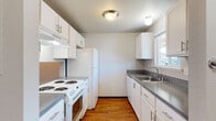 Located at 1248 Cedar Ave, Unit 26 in Marysville, WA, this two-floor residence offers a functional and comfortable layout spread across two levels. The main floor features an open living area with durable hardwood-style flooring that runs throughout, a staircase with black metal railing, and sliding glass doors that lead to an outdoor patio area, allowing natural light to fill the space. A half bathroom with a vanity and granite-style countertop is conveniently located on the main level. The galley-style kitchen is well-appointed with white cabinetry, gray laminate countertops, white appliances including an electric range, refrigerator, and dishwasher, plus a window above the sink that brings in additional natural light. Upstairs, the bedrooms feature plush carpeting and windows that provide outside views, creating comfortable and quiet retreats. A full bathroom on the upper level includes a tub/shower combination, toilet, and a vanity with matching gray countertop. Additional highlights include baseboard heating, a ceiling fan in one of the upper-level rooms, and textured ceilings throughout. The overall aesthetic is clean and neutral, providing a versatile canvas for any living arrangement.