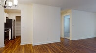 Located at 4701 Sheboygan Ave in Madison, Wisconsin, this single-floor unit offers a thoughtfully designed layout with a clean, neutral aesthetic throughout. Rich, warm-toned hardwood-style flooring flows through the main living areas, creating a cohesive and inviting atmosphere. The spacious living room is bright and open, featuring a large sliding glass door with vertical blinds that allows generous natural light to pour in, alongside a baseboard heating unit for year-round comfort. A chandelier elegantly marks the transition toward the dining area and kitchen. The galley-style kitchen is well-equipped with white shaker cabinetry, light quartz countertops, a stainless steel sink, and a full suite of stainless steel appliances including a refrigerator, range, and dishwasher. Under-cabinet lighting adds functional brightness to the workspace. The bedroom features plush carpeting and a sizable window that brings in natural light, complemented by baseboard heating. The bathroom is finished with white shaker-style cabinetry, a wide vanity with ample storage, a large mirror, and stylish globe lighting, all set atop the same warm hardwood-style flooring found throughout the unit. Clean white walls and simple, timeless finishes give the space a bright, move-in-ready feel.