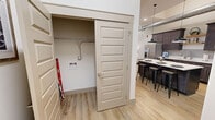 Located at 208 E Market St in Johnson City, TN, this one-bedroom, one-bathroom unit offers an efficient yet stylish layout with an open, airy feel throughout. Soaring ceilings with exposed industrial-style ductwork lend an urban loft character to the space, while light wood-tone flooring runs seamlessly through the main living areas.

The kitchen is a standout feature, boasting rich dark wood cabinetry, crisp white quartz countertops, a subway tile backsplash, open wood shelving, and stainless steel appliances. A center island with bar seating provides additional dining and prep space beneath striking pendant lights.

The living room is bathed in natural light from a dramatic arched window, further emphasizing the impressive ceiling height. The cozy yet open layout offers ample room for comfortable seating and relaxing.

The bedroom features plush carpeting, a generous closet, and its own arched window that mirrors the living area's architectural detail. Direct access to the bathroom adds everyday convenience. The bathroom is finished with dark wood vanity cabinetry and light wood-tone flooring, keeping the design cohesive throughout.

A dedicated laundry area with washer/dryer hookups and hallway access add practical functionality to this well-appointed urban residence.