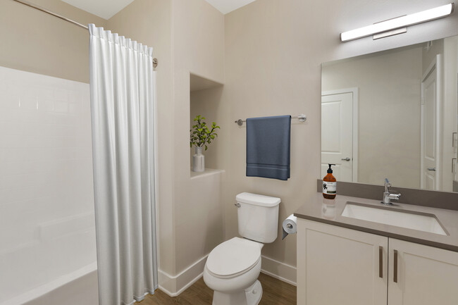 Renovated Package I bath with grey quartz countertops, white cabinetry, and hard surface flooring - Avalon Encino