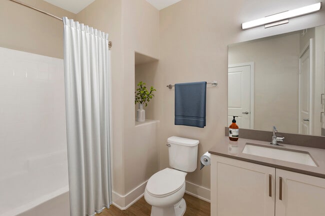 Renovated Package III bath with grey quartz countertops, white cabinetry, and hard surface flooring - Avalon Encino