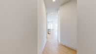 Located along West Sunset Boulevard in Los Angeles, this thoughtfully designed 2-bedroom, 2-bathroom unit offers a clean, contemporary aesthetic throughout. The open-concept kitchen and living area serves as the heart of the home, featuring herringbone-patterned hardwood flooring, warm wood cabinetry extending to the ceiling, a bold dark marble backsplash, stainless steel appliances, and a central island with a sleek countertop — ideal for both cooking and entertaining. Recessed lighting illuminates the space, which flows seamlessly into the living area brightened by a large window with views of the surrounding neighborhood. Both bedrooms continue the herringbone hardwood flooring and are finished with crisp white walls, creating a calm and versatile canvas. The primary bedroom offers generous proportions, while the second bedroom features corner windows that frame lush palm tree views, flooding the room with natural California sunlight. Built-in sliding closets provide practical storage. The two bathrooms are finished with light wood vanities, dark stone countertops, and neutral tile flooring. One bathroom features a backlit LED vanity mirror, while the other includes a full soaking tub with subway tile surround. Clean lines and a neutral palette unify the entire space.