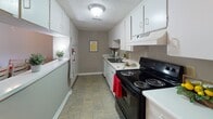 This two-story residence offers a well-organized layout across two levels, connecting living and sleeping areas via carpeted stairs with white-painted railings. The main level features an open-concept living and dining area with warm hardwood flooring, providing a welcoming communal space. The galley-style kitchen is efficiently designed with ample white cabinetry on both sides, a double basin sink, electric range, and tile flooring — offering practical functionality for everyday cooking.

The upper level hosts multiple bedrooms, each finished with plush wall-to-wall carpeting and fitted with large windows dressed in vertical blinds that invite natural light. The primary bedroom is notably spacious, featuring a sliding glass door that opens to an outdoor balcony, providing pleasant outdoor views. Additional bedrooms offer comfortable proportions with closet access and similarly bright window arrangements.

Two full bathrooms serve the home, each featuring a tub-shower combination, toilet, vanity with white cabinetry, and tile flooring. The textured ceilings are consistent throughout the home, contributing to its classic residential character. Overall, the space presents a functional and comfortable layout well-suited for everyday living.