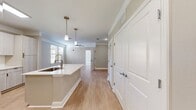 This contemporary 570 square foot apartment in Oklahoma City offers a well-designed living space. The heart of the home is a modern kitchen, boasting white cabinetry, stainless steel appliances, and a convenient island that doubles as a dining area. The open-concept layout seamlessly connects the kitchen to the living area, creating a spacious feel.

The bedroom, measuring 130 square feet, features plush carpeting and large windows that flood the space with natural light. A ceiling fan adds both style and functionality. The bathroom is efficiently designed with a combined tub and shower, complete with built-in shelving for storage.

Throughout the apartment, neutral tones dominate, with light wood-look flooring in the main living areas and white walls creating a bright, airy atmosphere. The closet space is generous, with wire shelving systems for organized storage.

Energy-efficient features include a programmable thermostat and modern lighting fixtures. The apartment's single floor layout ensures easy accessibility, while the overall design maximizes the use of space in this compact yet comfortable urban dwelling.