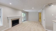 Located at 100 Calibre Lake Pkwy SE in Smyrna, GA, this one-bedroom, one-bathroom unit offers a well-planned single-floor layout. The combined kitchen and living room serves as the heart of the home, where the living area features plush carpeting, crown molding, recessed lighting, a classic fireplace with a white mantel, and a sliding glass door opening to a private balcony with wooded views. The kitchen is outfitted with warm honey-toned wood cabinetry, light stone countertops, stainless steel appliances including a gas range and refrigerator, a peninsula for additional workspace, and hardwood-style flooring. The bedroom offers comfortable carpeting, a ceiling fan, a window with natural views, and direct access to a walk-in closet with built-in shelving. The bathroom includes a full tub-shower combo with clean white tile surround. Additional spaces include a utility room, hallway, and dedicated closet storage. Throughout the unit, neutral paint tones and consistent finishes create a cohesive and practical living environment.
