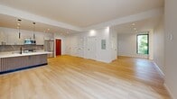 Located at 229 Willett Ave in Port Chester, NY, this thoughtfully designed 2-bedroom residence offers a well-appointed single-floor layout with a clean, contemporary aesthetic throughout. The open-concept kitchen and living area serves as the heart of the home, showcasing white shaker-style cabinetry, a striking marble-look tile backsplash, and a large quartz waterfall island with an integrated sink and stylish slatted wood paneling at its base. Stainless steel appliances, including a French door refrigerator, range, and microwave, complete the chef-ready kitchen. Sleek pendant lighting and recessed ceiling lights add a modern finishing touch. The living area extends generously from the kitchen, featuring light-toned hardwood flooring that continues seamlessly throughout the entire residence. Both bedrooms are well-sized, bathed in natural light from street-facing windows, and finished with the same warm hardwood floors and crisp white walls. The spacious primary bedroom provides ample room for comfortable living. A dedicated hallway connects the rooms and includes a closet for additional storage. The overall design is clean and minimalist, presenting a bright, move-in-ready home in the heart of Port Chester.