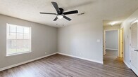 Located at 160 State Line Road in Clarksville, Tennessee, this 2-bedroom, 1-bathroom residence offers a practical and comfortable single-floor layout. Throughout the unit, wood-look plank flooring and neutral gray walls create a clean, cohesive aesthetic complemented by white baseboards and textured ceilings.

The combined kitchen and living area forms the heart of the home. The kitchen features warm honey-toned wood cabinetry, white appliances including a range and refrigerator, a stainless steel dishwasher, a double sink, and a stylish track light fixture overhead. The adjacent living area is open and airy, with a ceiling fan and direct access to the entry door.

The primary bedroom is generously sized, offering a ceiling fan with light, a large double-door closet for ample storage, and windows that bring in natural light. The second bedroom also includes a ceiling fan and window, providing a bright and comfortable space.

The full bathroom is well-appointed with warm wood-toned cabinetry, a white countertop with a single sink, a mirror, and a full tub-shower combination. The consistent wood-look flooring carries through into the bathroom, tying the unit together seamlessly. A utility panel is conveniently located near the kitchen entrance.