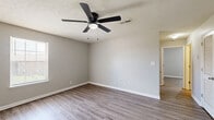 Located at 160 State Line Road in Clarksville, Tennessee, this 2-bedroom, 1-bathroom residence offers a practical and comfortable single-floor layout. Throughout the unit, wood-look plank flooring and neutral gray walls create a clean, cohesive aesthetic complemented by white baseboards and textured ceilings.

The combined kitchen and living area forms the heart of the home. The kitchen features warm honey-toned wood cabinetry, white appliances including a range and refrigerator, a stainless steel dishwasher, a double sink, and a stylish track light fixture overhead. The adjacent living area is open and airy, with a ceiling fan and direct access to the entry door.

The primary bedroom is generously sized, offering a ceiling fan with light, a large double-door closet for ample storage, and windows that bring in natural light. The second bedroom also includes a ceiling fan and window, providing a bright and comfortable space.

The full bathroom is well-appointed with warm wood-toned cabinetry, a white countertop with a single sink, a mirror, and a full tub-shower combination. The consistent wood-look flooring carries through into the bathroom, tying the unit together seamlessly. A utility panel is conveniently located near the kitchen entrance.