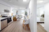 Located at 5 Zappacosta Drive in Toronto, this well-designed one-bedroom, one-bathroom unit offers an efficient and thoughtfully planned layout across a single floor. The open-concept living and kitchen area creates a seamless flow, bathed in natural light from large windows that frame city views. Light wood laminate flooring runs throughout the main area, contributing to a clean, contemporary aesthetic.

The kitchen is equipped with stainless steel appliances, including a refrigerator and electric range, complemented by white cabinetry with ample storage and light countertops. A compact dining area adjacent to the kitchen provides a practical space for meals.

The living room benefits from a large window that draws in generous natural light and overlooks the surrounding cityscape, creating an airy, open feel despite the unit's compact footprint.

The bedroom is a comfortable retreat featuring a large window with outdoor views, a sliding-door closet, and room for a full-sized bed. The four-piece bathroom is finished with tile flooring, a vanity with under-sink storage, and a combined shower and tub. Throughout the unit, a bright white palette and thoughtful design choices maximize the sense of space and functionality.