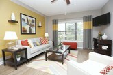 Located at 3385 Atlanta Rd SE in Smyrna, Georgia, this single-floor residence offers a thoughtfully designed layout with a welcoming open-concept living and dining area. The living room features warm wood-look flooring, large windows that invite natural light, a ceiling fan, and a neutral color palette accented by bold wall tones, creating a comfortable and stylish atmosphere.

The galley-style kitchen is well-equipped with granite countertops, white cabinetry, a mosaic tile backsplash, stainless steel appliances including a range and microwave, and a convenient breakfast bar with seating — connecting seamlessly to the living area.

The bedrooms offer plush carpeting, ceiling fans, and striking accent walls in deep navy and charcoal tones that add character to each room. Windows allow for natural light and outdoor views, enhancing the restful ambiance. Each bedroom provides ample space for comfortable furnishings.

The bathroom includes a full tub-shower combination with tile surround and wood-look flooring, maintaining the cohesive design aesthetic found throughout the home. Overall, the residence presents a modern, well-coordinated interior with practical features and a warm, livable character suited for everyday comfort.