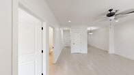 Located at 212 Commercial Dr in Athens, Alabama, this single-story 2-bedroom, 2-bathroom home offers a clean, modern aesthetic with a thoughtfully designed open floor plan. Light-toned tile flooring runs consistently throughout the entire home, creating a cohesive and bright atmosphere. Crisp white walls, recessed lighting, and matte black hardware accents contribute to a fresh, contemporary look.

The open-concept kitchen is a standout feature, equipped with white shaker-style cabinetry, stone countertops, stainless steel appliances including a French door refrigerator, electric range, built-in microwave, and dishwasher. A peninsula with pendant lighting connects the kitchen to the dining and living areas, making it ideal for entertaining. A pendant drum light anchors the combined living and dining space.

Both bedrooms are well-proportioned, each featuring natural light from windows with blinds and double closets with paneled doors and matte black hardware. The primary bedroom offers a generous footprint with direct access to its private bathroom. The bathrooms are finished in a clean, neutral palette — one featuring a walk-in shower with a built-in bench seat, stone-topped vanity, and matte black fixtures. A ceiling fan with light fixture is installed in the main living area, adding comfort and functionality throughout this move-in-ready home.