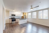 Located at 1608 S Dearborn St in Seattle's Beacon Hill neighborhood, this 2-bedroom, 1-bathroom unit offers a thoughtfully designed, modern layout across a single floor. The open-concept kitchen and living area serves as the heart of the home, featuring a central island with dark countertops, a full suite of stainless steel appliances including a gas range, microwave, and refrigerator, and a mix of white gloss upper cabinets with warm wood-tone lower cabinets. Track lighting illuminates the kitchen, while a ceiling fan enhances comfort in the living area. Large windows flood the combined space with natural light and provide views of the surrounding neighborhood. Rich, dark hardwood-style flooring runs throughout the entire unit, lending a cohesive and contemporary feel. Both bedrooms are well-proportioned, with the primary bedroom offering ample space, a ceiling fan with light, and access to closets with sliding doors. The second bedroom features a large window with natural light. The bathroom is cleanly finished with a full tub and shower, a wood-tone vanity with dark countertop, and hardwood-style flooring. Three closets provide generous storage throughout the unit, completing this efficiently designed Seattle home.