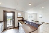 Located at 1100 Rosa Way in Bozeman, Montana, this single-floor, 2-bedroom, 3-bathroom home offers a well-organized layout with modern finishes throughout. The entrance leads into an open-concept kitchen and living area that serves as the heart of the home. The kitchen is equipped with white shaker-style cabinetry, dark wood-toned countertops featuring a double-basin sink, stainless steel appliances including a refrigerator and range, and light wood-look flooring that extends into the living area. Recessed lighting and multiple windows allow natural light to flow freely through the space. A charming rustic barn-style door adds a distinctive design accent near the entrance corridor. The in-unit laundry area is conveniently located adjacent to the kitchen, housing a full-size washer and dryer. The bedrooms feature plush carpeting, natural light from windows with wood-trimmed sills, and closets with built-in hanging rods. The primary bedroom is generously sized with its own dedicated space. The bathrooms are clean and functional, with one featuring a full soaking tub and shower combo, white cabinetry, and wood-look flooring. Additional highlights include a closet, a balcony, and a baseboard heating system.