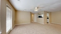 Located at 701 Carver Rd in Griffin, Georgia, this single-floor unit offers a practical and well-organized layout designed for comfortable everyday living. The entry foyer features wood-look flooring and provides access to both the main living area and adjacent spaces. The open living room is generously proportioned, finished with neutral-toned carpet and warm beige walls, and centered beneath a ceiling fan with integrated lighting. A textured ceiling adds subtle character throughout the space. The living area connects seamlessly to the kitchen via a pass-through opening, creating an open and communicative layout. The kitchen is equipped with white cabinetry, dark countertops, and black appliances including a refrigerator and range, all set over durable wood-look flooring. A dedicated laundry area features washer and dryer hookups alongside an electrical panel, offering added convenience. The bedrooms are carpeted and filled with natural light from window blinds, with one bedroom featuring a spacious walk-in closet equipped with wire shelving. The full bathroom includes a tub-shower combo with tiled surround, wood-look flooring, white vanity cabinetry, and a dark countertop. Throughout, the consistent neutral palette and clean finishes create a cohesive and move-in ready environment.