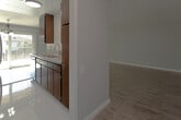 Located at 421 E Bay State St in Alhambra, California, this single-floor unit offers a clean, modern aesthetic throughout. The interior is finished with light gray walls and wood-look flooring that runs seamlessly across the main living areas, creating a bright and cohesive feel.

The open-concept kitchen and dining area serve as the heart of the space. The kitchen is equipped with rich dark wood cabinetry, granite-style countertops, a stainless steel sink, a stainless electric range with overhead ventilation, and a dishwasher. Abundant upper and lower cabinet storage provides practical functionality. A peninsula counter with additional cabinetry separates the kitchen from the dining area, which is accented by an elegant multi-arm chandelier and receives generous natural light through vertical blind-covered sliding doors and windows.

A wall-mounted air conditioning unit in the living/dining area ensures year-round climate comfort. The bedroom features light hardwood-style flooring, a window with vertical blinds for natural light, and full-width mirrored sliding closet doors that enhance the sense of space. The bathroom is finished in crisp white tones, featuring a white vanity with a marble-look countertop, a glass-enclosed shower, and a window that allows natural ventilation. The overall ambiance is fresh, well-maintained, and move-in ready.