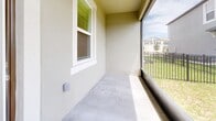 Located at 17224 Auburn Arch Loop in Wimauma, Florida, this two-story home offers a well-designed layout spread across two floors. The main level provides generous living space with light-toned tile flooring throughout, creating a clean and cohesive look. The open-concept kitchen is outfitted with white shaker cabinetry, a subway tile backsplash, quartz countertops, and stainless steel appliances including a side-by-side refrigerator, range, and microwave. The adjacent living room is bright and airy, with a staircase leading to the upper level. A screened patio off the main floor offers outdoor views of the surrounding neighborhood. Upstairs, three carpeted bedrooms provide comfortable retreats, including a spacious primary suite featuring a tray ceiling with a ceiling fan. The bathrooms are finished in a crisp, contemporary style with light wood-look tile floors, white vanities, and white subway tile surrounds — one bathroom includes a walk-in glass shower, while another features a tub-shower combo. A dedicated laundry room on the upper floor houses a full-size washer and dryer. The home also includes an attached garage with an automatic opener, adding everyday convenience to this well-appointed Florida residence.