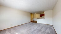 Located at 5591 Rustling Way Ln in Galloway, Ohio, this 2-bedroom, 1-bathroom single-story home offers a functional and well-organized layout. The open-concept main area seamlessly combines the living room, dining space, and kitchen, creating an inviting and versatile gathering zone. The living room features soft carpeting and a textured ceiling, while natural light filters in through a window near the entryway. The galley-style kitchen is equipped with rich warm-toned wood cabinetry, granite-look countertops, hardwood-style flooring, and white appliances including a gas range, refrigerator, and dishwasher — providing ample workspace and storage. A pass-through counter connects the kitchen to the dining and living area. Both bedrooms are carpeted and offer a calm, neutral palette, with the spacious primary bedroom featuring a walk-in closet outfitted with wire shelving for organized storage. The full bathroom includes a tub-shower combination and hardwood-style flooring. Additional highlights include three closets throughout, a dedicated laundry area, a utility room, and a hallway connecting the private spaces. Textured ceilings are consistent throughout the home, contributing to its classic residential character.