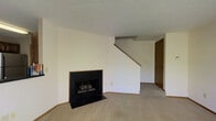 Located at 6564 Millridge Cir in Dublin, Ohio, this two-story home offers a straightforward and functional layout across two levels. The main living area serves as the heart of the home, finished with wall-to-wall carpeting that adds warmth underfoot. A standout feature of this space is the wood-framed fireplace with a black surround, providing a classic focal point and a cozy atmosphere. A textured ceiling runs throughout, lending the space a traditional residential character. Neutral, cream-toned walls keep the interior feeling bright and open, offering a versatile backdrop for a variety of décor styles. A staircase with a wooden handrail rises from the main living area, connecting seamlessly to the upper floor and adding a sense of vertical dimension to the space. A doorway off the main area provides access to additional rooms, supporting a well-connected floor plan. The overall ambiance is clean, quiet, and move-in ready, reflecting the calm residential character of the Millridge Circle neighborhood in Dublin — a well-regarded community in central Ohio known for its suburban charm and convenient access to local amenities.