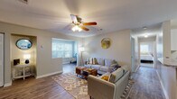 Located in Savannah, GA, this single-story home offers a thoughtfully designed layout that balances comfort and functionality. The open living area serves as the heart of the home, featuring durable hardwood-style flooring, neutral tones, and a ceiling fan with built-in lighting. A connected flex space — ideal as a home office or reading nook — benefits from a large window that fills both areas with abundant natural light. Decorative touches, including a gold-framed round mirror, add a modern flair to the living space. Bifold closet doors provide convenient built-in storage nearby. The kitchen is outfitted with crisp white shaker cabinetry, granite-style countertops, and tile flooring, offering ample storage and prep space. The bedrooms are warm and inviting, with plush carpeting, generous windows with blinds, and well-sized closets — including a walk-in closet in one bedroom. The bathroom features a white vanity with granite-style countertops, dual mirrors, and tile flooring. Throughout the home, a cohesive neutral color palette and consistent finishes create a clean, move-in-ready atmosphere suited for a variety of lifestyles.