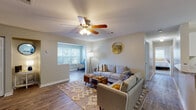 Located in Savannah, GA, this single-story home offers a thoughtfully designed layout that balances comfort and functionality. The open living area serves as the heart of the home, featuring durable hardwood-style flooring, neutral tones, and a ceiling fan with built-in lighting. A connected flex space — ideal as a home office or reading nook — benefits from a large window that fills both areas with abundant natural light. Decorative touches, including a gold-framed round mirror, add a modern flair to the living space. Bifold closet doors provide convenient built-in storage nearby. The kitchen is outfitted with crisp white shaker cabinetry, granite-style countertops, and tile flooring, offering ample storage and prep space. The bedrooms are warm and inviting, with plush carpeting, generous windows with blinds, and well-sized closets — including a walk-in closet in one bedroom. The bathroom features a white vanity with granite-style countertops, dual mirrors, and tile flooring. Throughout the home, a cohesive neutral color palette and consistent finishes create a clean, move-in-ready atmosphere suited for a variety of lifestyles.