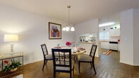This two-story home in Ocala, FL (34474) offers a thoughtfully designed layout across two levels, blending functional living spaces with warm, inviting finishes throughout. The main floor features rich hardwood flooring that flows through the living room, dining area, and kitchen. The living room provides a relaxed gathering space, while the dining area is anchored by an elegant chandelier and opens seamlessly to the kitchen via a pass-through window. The kitchen is equipped with white cabinetry, ample counter space, a range, dishwasher, and a window that brings in natural light. A carpeted staircase with a classic wood banister connects the main level to the upper floor, where the bedrooms are located. The bedrooms are finished with plush carpet and windows that allow for natural light, offering a quiet and comfortable retreat. A dedicated office space on the upper level features a window and neutral carpet, ideal for remote work or study. A well-lit bathroom with a vanity and mirror serves the upper level. Throughout the home, textured ceilings, clean white walls, and thoughtful details create a cohesive and comfortable living environment suited for everyday life in central Florida.
