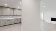 Located in the desirable West Los Angeles neighborhood of 90025, this single-story, 3-bedroom, 2-bathroom home offers a clean, modern aesthetic throughout. Light hardwood-style flooring flows seamlessly across all rooms, creating a cohesive and airy feel.

The spacious living room is a standout, featuring a sleek built-in fireplace, recessed lighting, and large sliding glass doors that open to an outdoor area, flooding the space with natural light. The kitchen is thoughtfully designed with shaker-style gray cabinetry, brushed nickel hardware, white quartz countertops, and a subway tile backsplash, offering ample storage and counter space.

The generously sized primary bedroom provides a comfortable retreat with a mirrored sliding closet. Additional bedrooms include closets and large windows that invite natural light and neighborhood views. Each room maintains the home's consistent neutral palette of whites and soft grays.

The two bathrooms are finished with marble-style countertops, modern vanities, and glass-enclosed walk-in showers with tile surrounds. One bathroom conveniently includes an in-unit stacked washer and dryer. Throughout, brushed nickel fixtures and clean lines reinforce the home's contemporary character, making it a well-appointed residence in a prime Los Angeles location.