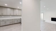 Located in the desirable West Los Angeles neighborhood of 90025, this single-story, 3-bedroom, 2-bathroom home offers a clean, modern aesthetic throughout. Light hardwood-style flooring flows seamlessly across all rooms, creating a cohesive and airy feel.

The spacious living room is a standout, featuring a sleek built-in fireplace, recessed lighting, and large sliding glass doors that open to an outdoor area, flooding the space with natural light. The kitchen is thoughtfully designed with shaker-style gray cabinetry, brushed nickel hardware, white quartz countertops, and a subway tile backsplash, offering ample storage and counter space.

The generously sized primary bedroom provides a comfortable retreat with a mirrored sliding closet. Additional bedrooms include closets and large windows that invite natural light and neighborhood views. Each room maintains the home's consistent neutral palette of whites and soft grays.

The two bathrooms are finished with marble-style countertops, modern vanities, and glass-enclosed walk-in showers with tile surrounds. One bathroom conveniently includes an in-unit stacked washer and dryer. Throughout, brushed nickel fixtures and clean lines reinforce the home's contemporary character, making it a well-appointed residence in a prime Los Angeles location.