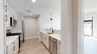 Located at 282 South Ave in Fanwood, NJ, this two-story, 2-bedroom, 2-bathroom residence offers a thoughtfully designed layout spread across two well-proportioned floors. The main level hosts an open-concept living, dining, and kitchen area bathed in a clean, modern aesthetic. The kitchen is outfitted with white shaker cabinetry, quartz countertops, a subway tile backsplash, stainless steel appliances including a gas range and dishwasher, and black-accented pendant lighting that adds a contemporary touch. A pantry and ample storage provide added functionality. Light wood-tone flooring flows seamlessly throughout both floors, complementing the bright, neutral palette. The upper level features two bedrooms with vaulted ceilings, ceiling fans, and windows that bring in generous natural light. The primary bedroom is generously sized and accompanied by multiple closets with built-in shelving. Both bathrooms are finished to a high standard, with one showcasing an LED-backlit vanity mirror, a glass-enclosed tiled shower, and marble-style flooring. A versatile loft space with soaring ceilings and a sleek metal railing overlooks the upper level. Additional highlights include a private balcony, multiple utility rooms, and abundant closet space throughout.