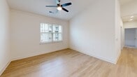 Located at 185 Ashford Cir in Asheville, NC, this well-appointed single-story home offers two bedrooms and two full bathrooms in a thoughtfully designed layout. Light-toned hardwood flooring flows throughout the main living areas, complemented by crisp white walls and recessed lighting that create a bright, clean aesthetic. The open kitchen is a standout feature, showcasing two-tone cabinetry with white upper shaker-style cabinets and dark lower cabinets, sleek white quartz countertops, a undermount sink with a matte black faucet, black appliances, and modern pendant lighting. The living room and kitchen share an open-concept flow, with ceiling fans adding comfort throughout. The primary bedroom features plush carpeting, a ceiling fan, and access to two closets, offering generous storage. The second bedroom also features carpet flooring, a ceiling fan, and a window with natural light. Both bathrooms are finished with matte black fixtures — one with a tiled tub-shower combo and the other with a glass-enclosed walk-in shower. A dedicated laundry room houses a full-size washer and dryer with overhead wire shelving. The home combines modern design with practical functionality in one of Asheville's established neighborhoods.