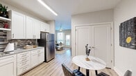 This thoughtfully designed 2-bedroom, 2-bathroom residence offers a functional and stylish single-floor layout. The open-concept kitchen is a standout feature, boasting crisp white shaker cabinetry, granite countertops, a decorative tile backsplash, and a full suite of stainless steel appliances including a range, microwave, dishwasher, and refrigerator. The kitchen flows naturally into a dining area and an inviting living room, which features wood-look plank flooring, a ceiling fan, and a glass door that brings in natural light and outdoor views. The primary bedroom is a comfortable retreat with plush carpeting, a large window overlooking greenery, a ceiling fan, and access to a dedicated walk-in closet. Its en-suite bathroom includes a granite-topped vanity with white cabinetry and a tub-shower combination. The second bedroom mirrors the same warm, carpeted comfort and natural light. The second bathroom offers a walk-in shower, granite vanity, and white cabinetry. Throughout the residence, neutral tones, clean lines, and consistent finishes create a cohesive and modern aesthetic. Two closets provide practical storage, completing this efficiently organized home.