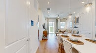 Located at 2507 Koji St in Mount Dora, Florida, this single-story home offers a thoughtfully designed layout that maximizes every square foot. Light wood-look flooring flows seamlessly throughout the space, complementing the bright, white-toned palette that defines the interior aesthetic.

The open-concept kitchen and living area serves as the heart of the home. The kitchen is outfitted with crisp white shaker cabinetry extending to the upper walls, white quartz countertops, a full suite of stainless steel appliances including a French door refrigerator, range, over-the-range microwave, and dishwasher, as well as a peninsula that provides additional seating and prep space. A window above the sink draws in natural light.

The living room is comfortable and airy, featuring recessed lighting, a ceiling fan, and a sliding glass door that opens to an outdoor area, offering a seamless indoor-outdoor connection.

The primary bedroom is a serene retreat, benefiting from multiple windows that invite natural light and outdoor views. Two full bathrooms serve the home, each finished with white cabinetry and clean, modern fixtures. A dedicated utility room with built-in wire shelving provides practical storage. The overall ambiance is clean, modern, and inviting — ideal for low-maintenance living in Central Florida.