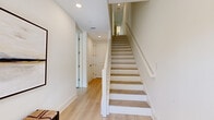 Located at 208 Park Lake Street in Orlando, FL, this contemporary three-story townhouse offers a well-designed layout across three distinct levels. The ground floor serves as an entry level, featuring light hardwood flooring, recessed lighting, and a clean staircase with white-painted risers and natural wood treads that connects all floors seamlessly.

The main living level, the most expansive floor, hosts an open-plan living room, dining area, and kitchen. The living room features high ceilings, large black-framed windows that flood the space with natural light, and views of the surrounding greenery. The dining area mirrors this brightness, with oversized windows overlooking a park-like setting. The kitchen is outfitted with white shaker cabinetry, quartz countertops, stainless steel appliances, and light hardwood floors throughout.

The bathrooms are finished with marble-style porcelain tile, glass-enclosed showers, and white vanities with quartz countertops. The spacious primary bedroom on the upper floor features recessed lighting, French doors admitting natural light, and generous proportions. Additional bedrooms are bright and well-sized, each with hardwood flooring and large windows. The home's consistent palette of white walls, light wood floors, and modern fixtures creates a cohesive, airy aesthetic throughout.