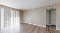 Located at 26696 E Ninth St in Highland, California, this single-floor residence offers a clean, modern interior with a cohesive neutral color palette and wood-look flooring carried throughout every room. The open living area is bright and welcoming, featuring large sliding glass doors dressed with vertical blinds that invite natural light and provide outdoor access. A ceiling fan adds comfort and functionality to the space. The kitchen is well-appointed with white cabinetry, granite-patterned countertops, and stainless steel appliances, creating a practical and attractive workspace. The bedrooms are generously sized with the same durable wood-look flooring, neutral wall tones, and windows with vertical blinds that allow for flexible light control. Six-panel interior doors are found throughout, contributing to a consistent and polished aesthetic. The bathroom features a full tub-shower combination with a curved rod, a white vanity topped with a granite-patterned countertop, and matching flooring that ties the space together seamlessly. Clean white baseboards and trim finish each room with a crisp, well-maintained look. The overall ambiance is bright, neutral, and move-in ready, offering a comfortable and functional living environment.